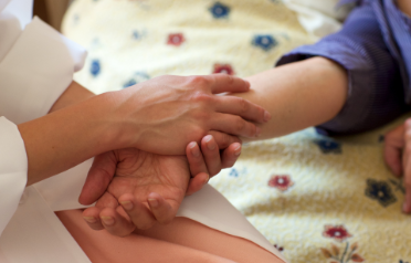 手を握り訪問診療のメリットを伝える画像